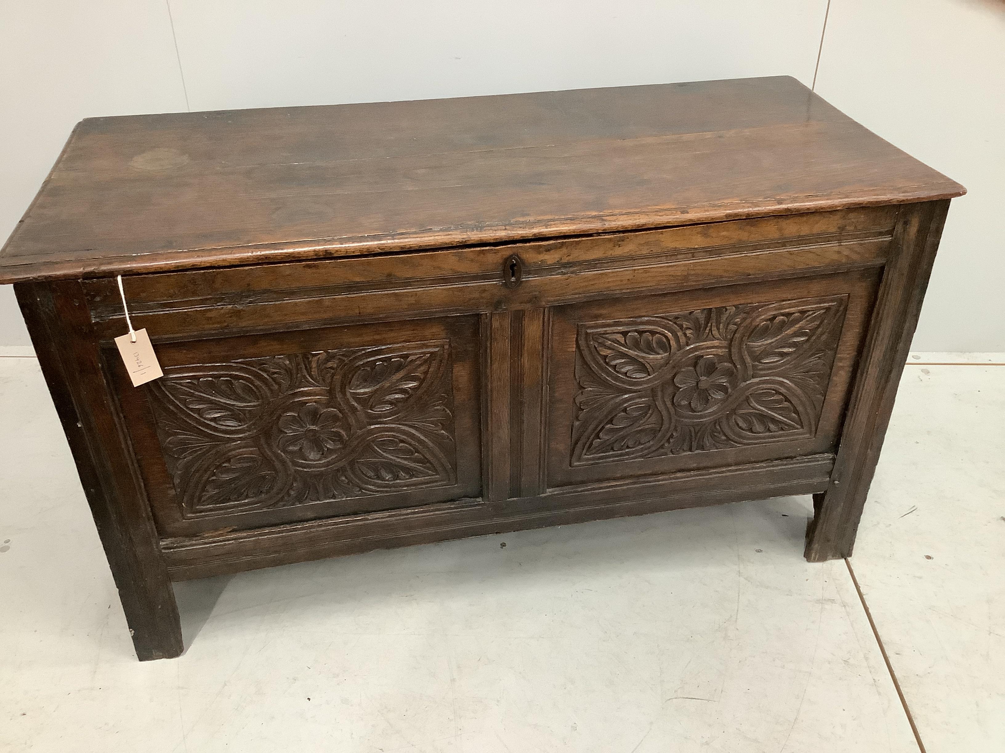 An 18th century carved panelled oak coffer, width 120cm, depth 51cm, height 67cm